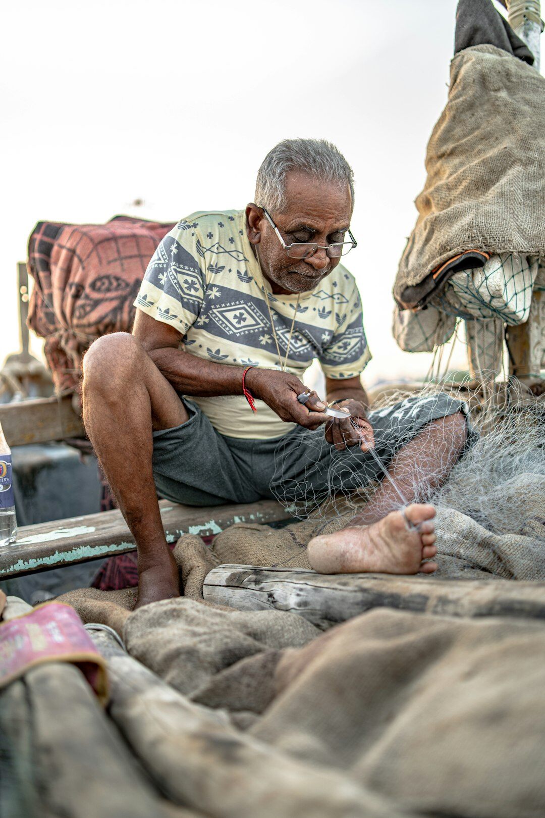 fisherman repairing nets