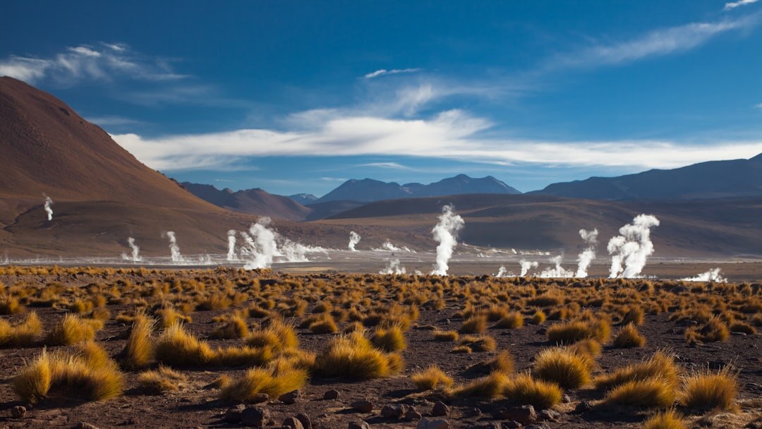 Vast red desert landscape of the Atacama with distant volcanoes